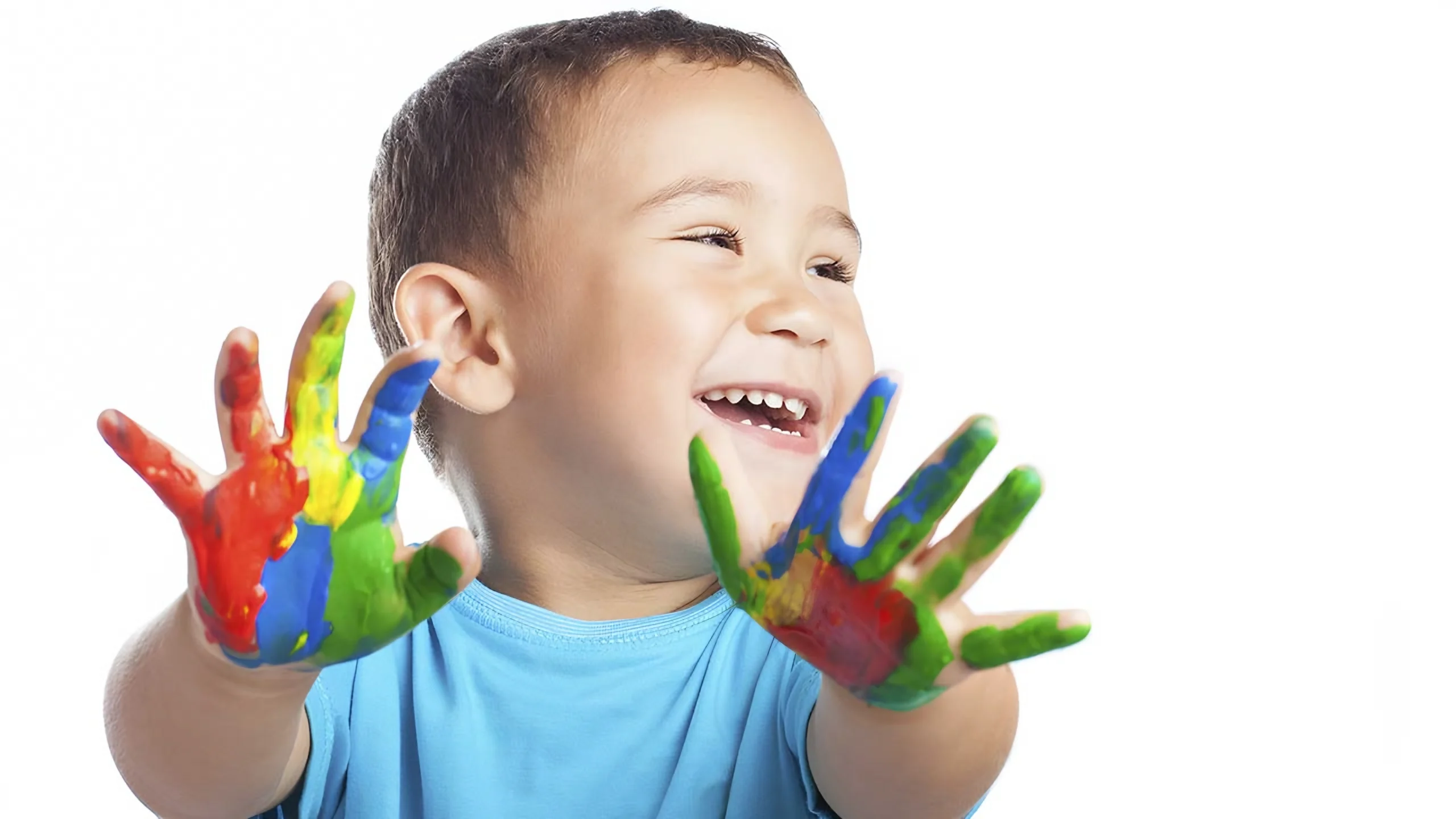 Criança sorrindo com as mãos sujas de tinta colorida